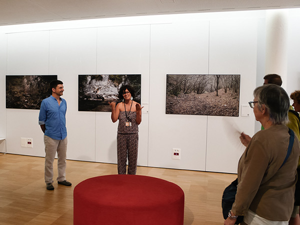 Pau Guerrero presentant el projecte fotogràfic *Paisatge i llegenda del comte Arnau* durant la seva exposició a la Biblioteca Carles Rahola de Girona